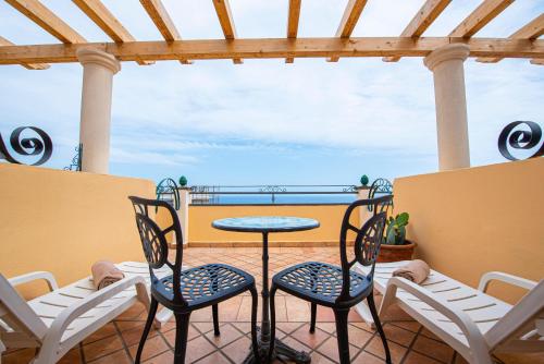 a patio with a table and chairs on a balcony at Baia Taormina - CDSHotels in Forza dʼAgro