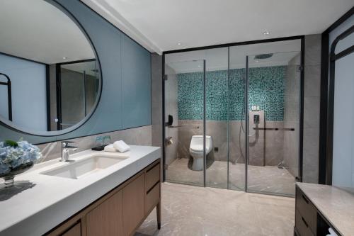 a bathroom with a sink and a shower with a toilet at Foreign Trade Centre C&D Hotel,Fuzhou in Fuzhou