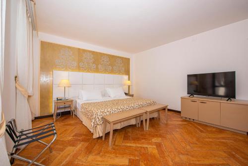 a bedroom with a bed and a flat screen tv at Baia Taormina - CDSHotels in Forza dʼAgro