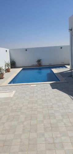 a swimming pool in the middle of a courtyard at Villa Yahia Djerba in Bou Menjel