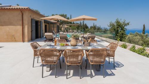 an outdoor dining area with a table and chairs at Fiscardo Sunny Villas in Fiskardho