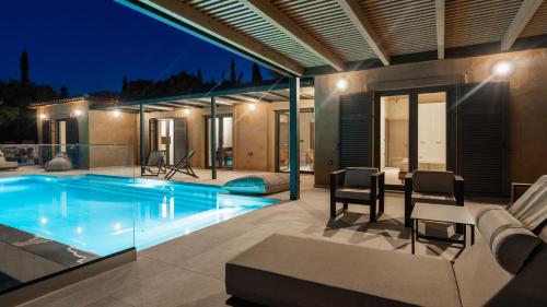 a house with a swimming pool at night at Fiscardo Sunny Villas in Fiskardho