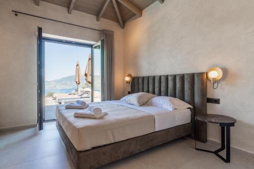 a bedroom with a large bed and a large window at Fiscardo Sunny Villas in Fiskardho