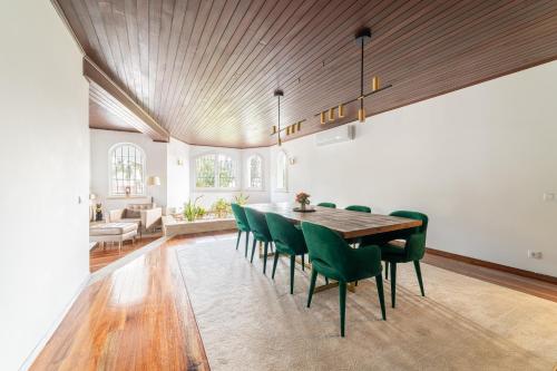 a dining room with a table and green chairs at Portuguese Luxury Villa in Setúbal