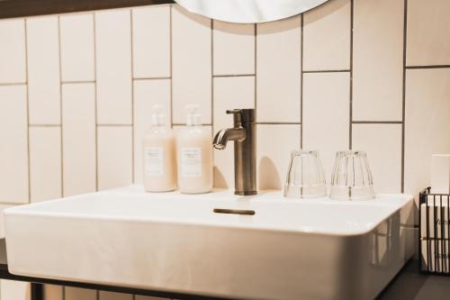 a bathroom sink with two bottles and a faucet at Exeter Hotel in Reykjavík