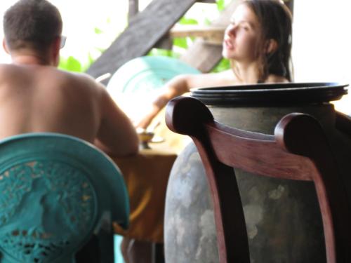 a man and a woman sitting next to a vase at Why Not Guest house in Hikkaduwa