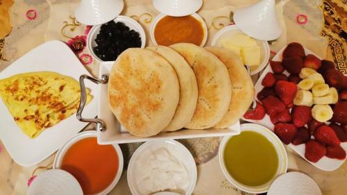 a tray of food with pancakes and fruits and dip at Dar Baddi in Marrakech