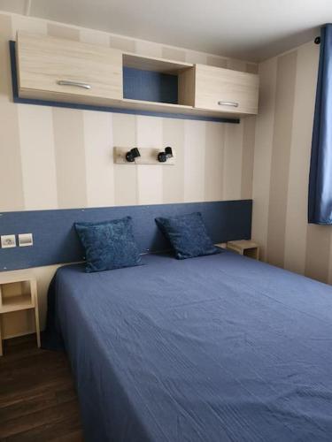 - une chambre avec un lit bleu et 2 oreillers bleus dans l'établissement camping soleiluna, à Herm