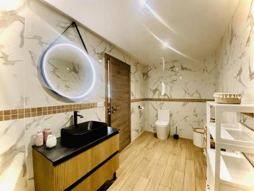 a bathroom with a black sink and a toilet at Gite L'Echo des 2 Baies in Saint-Quentin-en-Tourmont