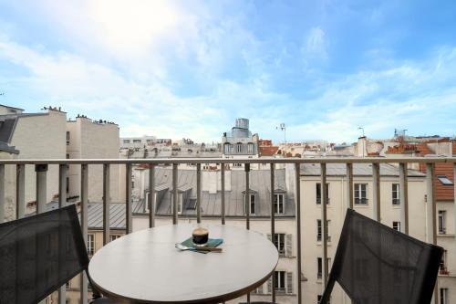 une table sur un balcon avec vue sur une ville dans l'établissement Studio avec balcon - Paris 17e, à Paris