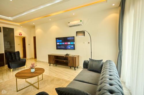 a living room with a couch and a table at AIDEN HOMES AND APARTMENTS HOTEl in Koforidua