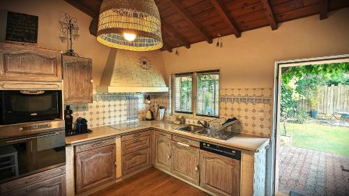 une cuisine avec des armoires en bois et un évier dans l'établissement Bordeaux Océan Médoc Maison de charme classée 4 étoiles, à Parempuyre