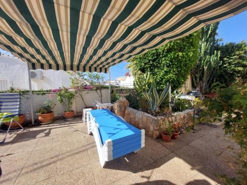 a blue and white bed under a large umbrella at Chalet Los Almendros con piscina privada in Calpe