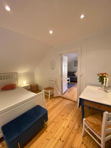 a bedroom with a bed and a desk and a table at Sjarmerende leilighet i hjertet av Risør in Risør