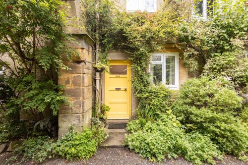 a yellow door on the side of a building at Host & Stay - Summerhill Court Lodges in Alnwick