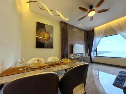a dining room with a table with chairs and a ceiling fan at Imperio Residence Melaka in Melaka
