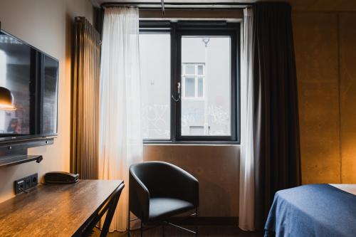 a room with a desk and a chair and a window at Exeter Hotel in Reykjavík