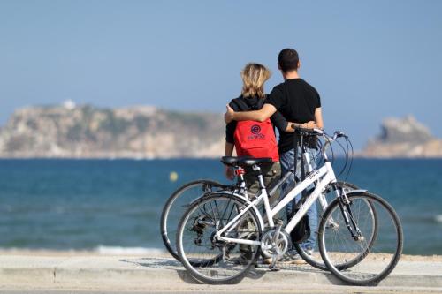 a man and a woman standing next to their bikes at Payet Apartments in L'Estartit