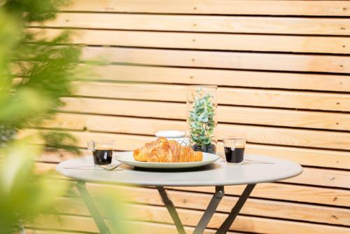 a table with a plate of croissants and two glasses at L'Amour d'Or Centre Historique in Besançon