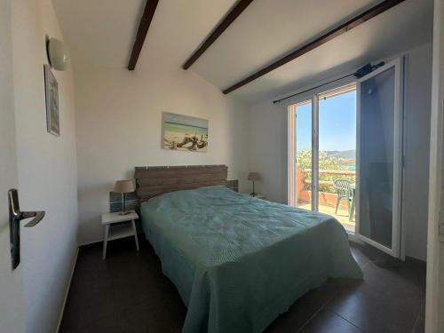 une chambre avec un lit et une grande fenêtre dans l'établissement E Casette Di Santa Giulia, à Porto-Vecchio