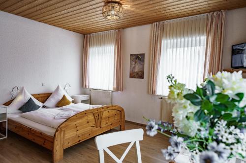 a bedroom with a bed and flowers in a room at Landgasthof Ochsen in Neresheim