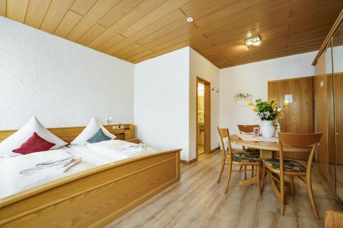 a bedroom with a bed and a table and chairs at Landgasthof Ochsen in Neresheim