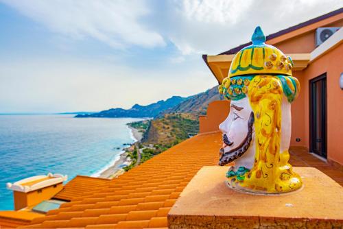 a yellow fire hydrant sitting on the ledge of a house at Baia Taormina - CDSHotels in Forza dʼAgro