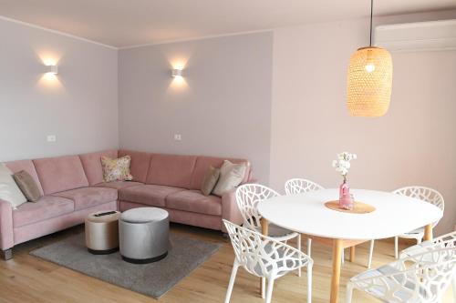 a living room with a pink couch and a table at Favolabella The Loft in Bardolino