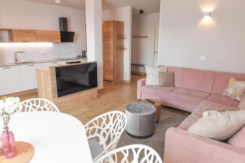 a living room with a pink couch and a table at Favolabella The Loft in Bardolino