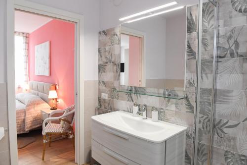 a bathroom with a sink and a mirror and a bed at Favolabella The Loft in Bardolino