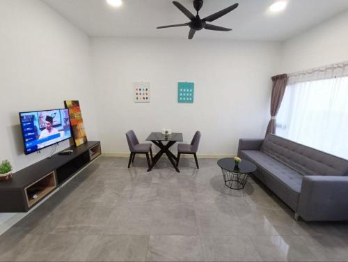 a living room with a couch and a tv and a table at Imperio Residence Melaka in Melaka