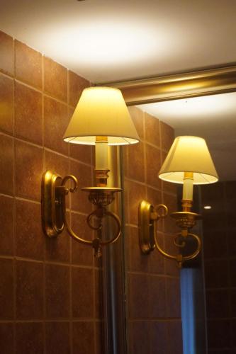 a pair of lights on a wall in front of a mirror at City Hotel Xiamen-Free Welcome Fruits in Xiamen
