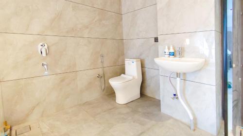 a bathroom with a toilet and a sink at Hotel Nova Bizz in Rajkot