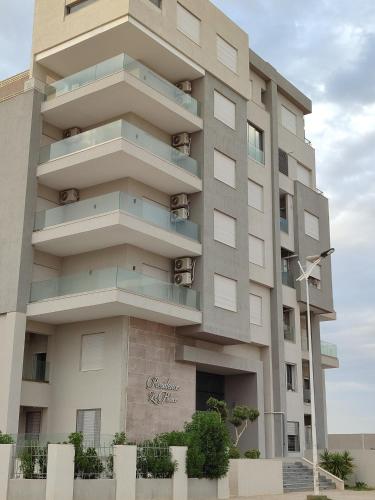 a building with balconies on the side of it at Sublime appartement le Palace Hammamet Nord Mrezga - Family only in Hammamet
