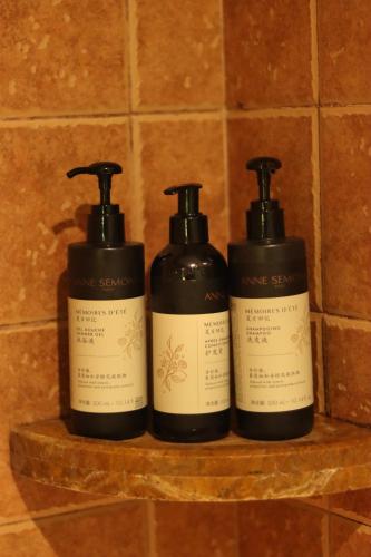 three bottles of soap sitting on a shelf at City Hotel Xiamen-Free Welcome Fruits in Xiamen