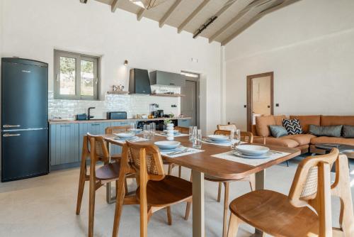 a kitchen and living room with a wooden table and chairs at Fiscardo Sunny Villas in Fiskardho