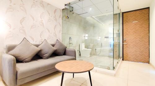 a living room with a couch and a table at Hotel Nova Bizz in Rajkot