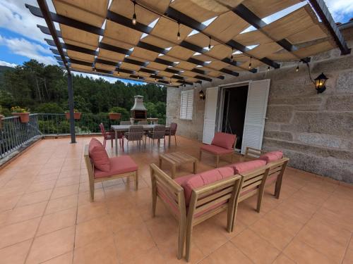 a patio with a table and chairs and a wooden pergola at Villa Rio in Tangil
