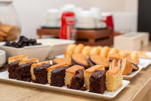 a table with several different types of cakes on plates at Hotel Yola in Altafulla