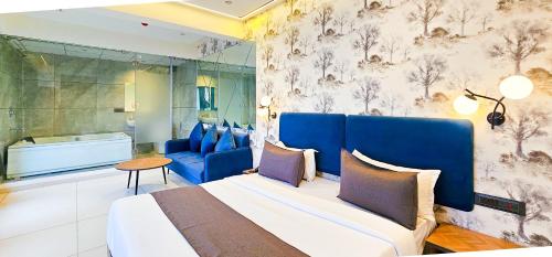 a bedroom with a large bed and a couch at Hotel Nova Bizz in Rajkot