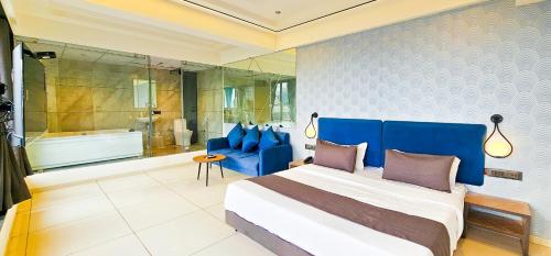 a bedroom with a large bed and a bath tub at Hotel Nova Bizz in Rajkot