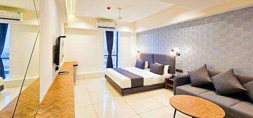 a hotel room with a bed and a couch at Hotel Nova Bizz in Rajkot