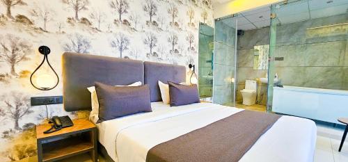 a bedroom with a large bed and a shower at Hotel Nova Bizz in Rajkot