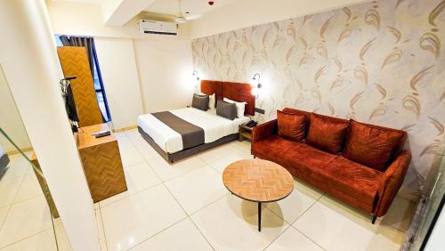 a hotel room with a bed and a couch at Hotel Nova Bizz in Rajkot