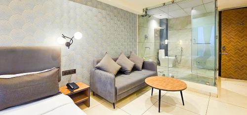 a living room with a couch and a table at Hotel Nova Bizz in Rajkot
