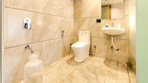 a bathroom with a toilet and a sink at Hotel Nova Bizz in Rajkot