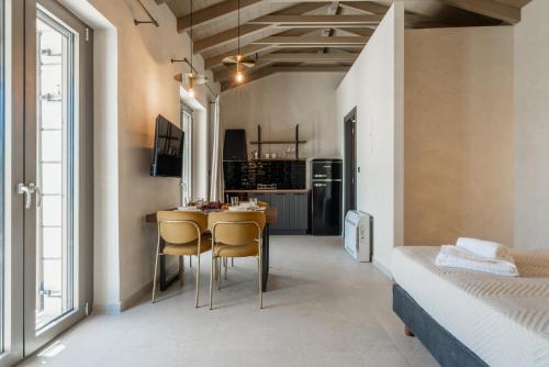a room with a table and chairs and a bed at Fiscardo Sunny Villas in Fiskardho
