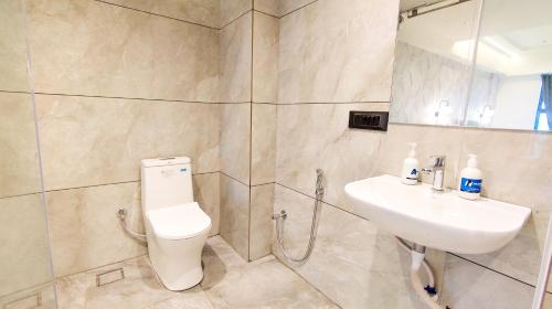 a bathroom with a toilet and a sink at Hotel Nova Bizz in Rajkot