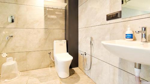 a bathroom with a toilet and a sink at Hotel Nova Bizz in Rajkot