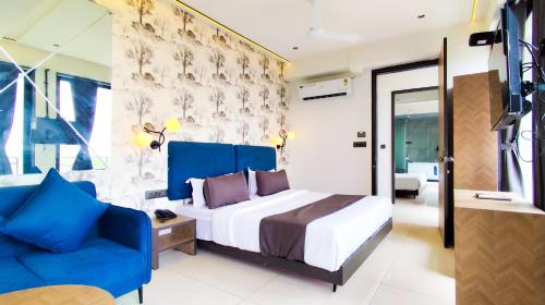 a bedroom with a bed and a blue couch at Hotel Nova Bizz in Rajkot